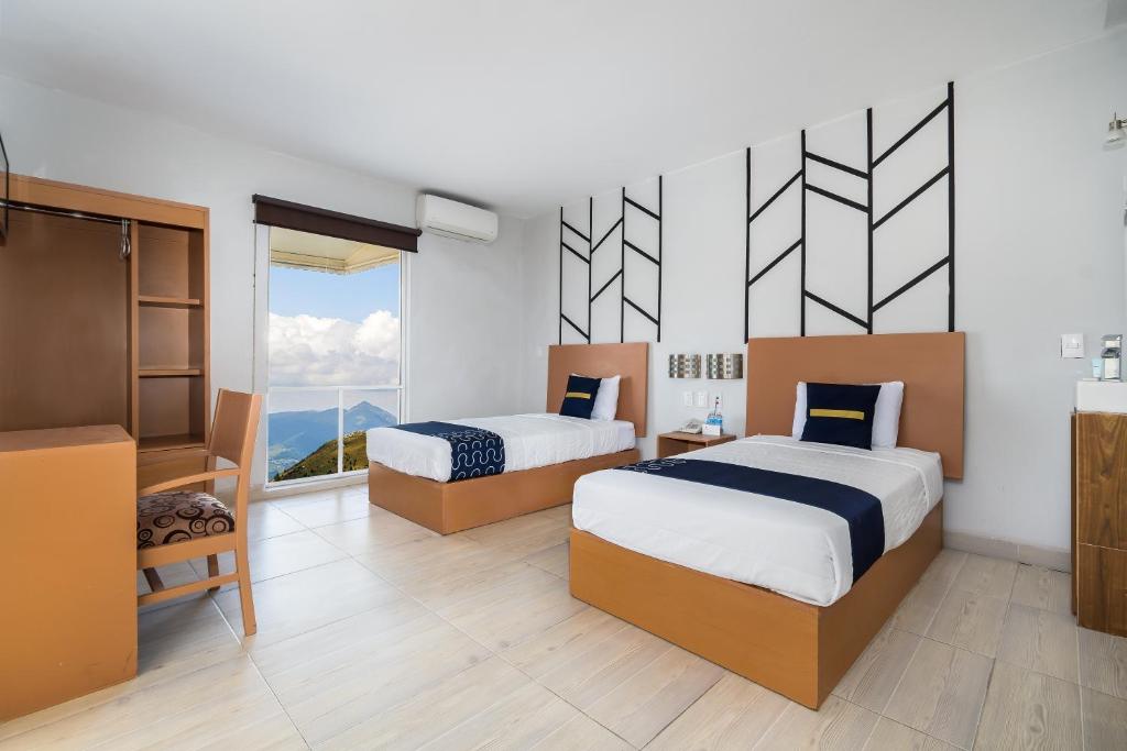 托雷翁Hotel Plaza Regina Torreon的一间卧室设有两张床和大窗户