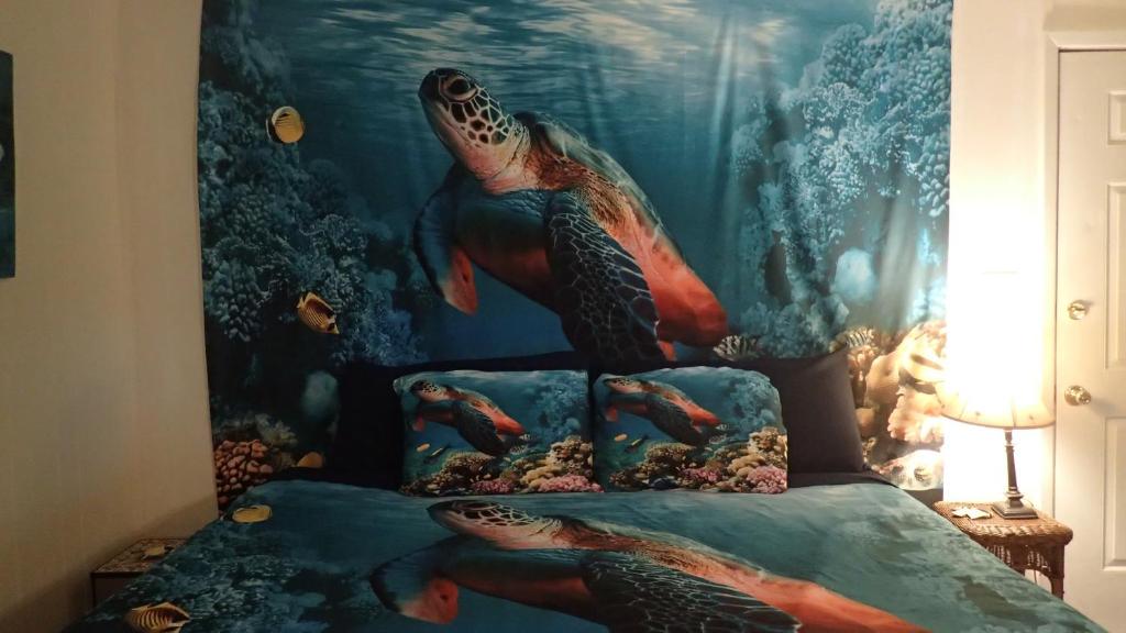微风湾Reef Dreamer Artist’s Retreat的一间卧室配有一张带绘画背心的床