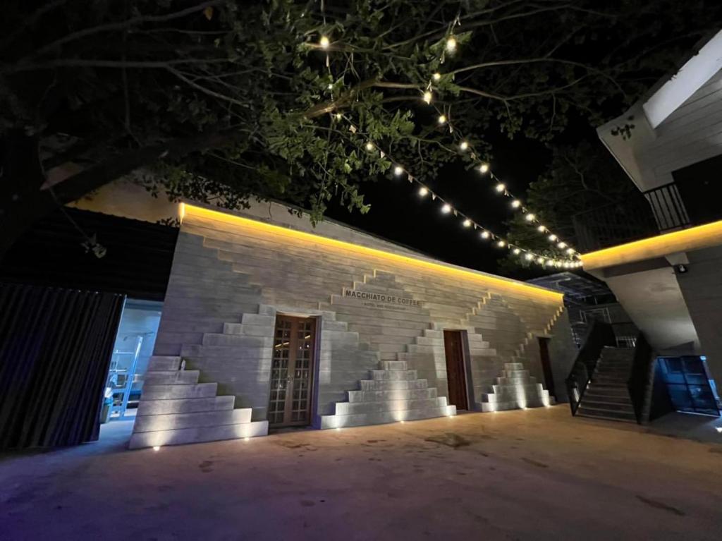 沙湾拿吉Macchiato Resort Savannakhet Opposite Thai Embassy的一座砖砌的建筑,晚上有灯