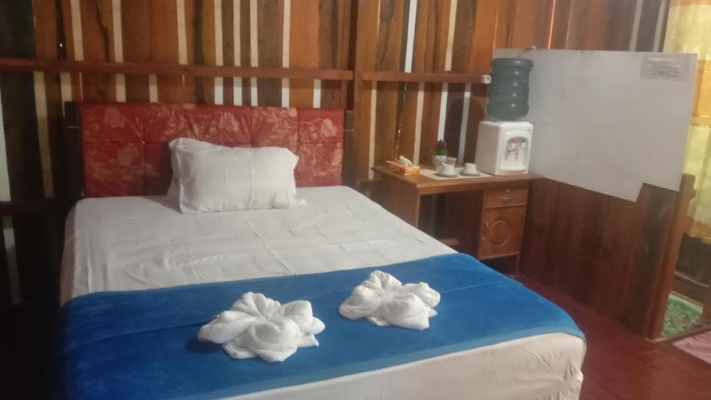 TualYohana Cottage的一间卧室配有一张床,上面有两条毛巾