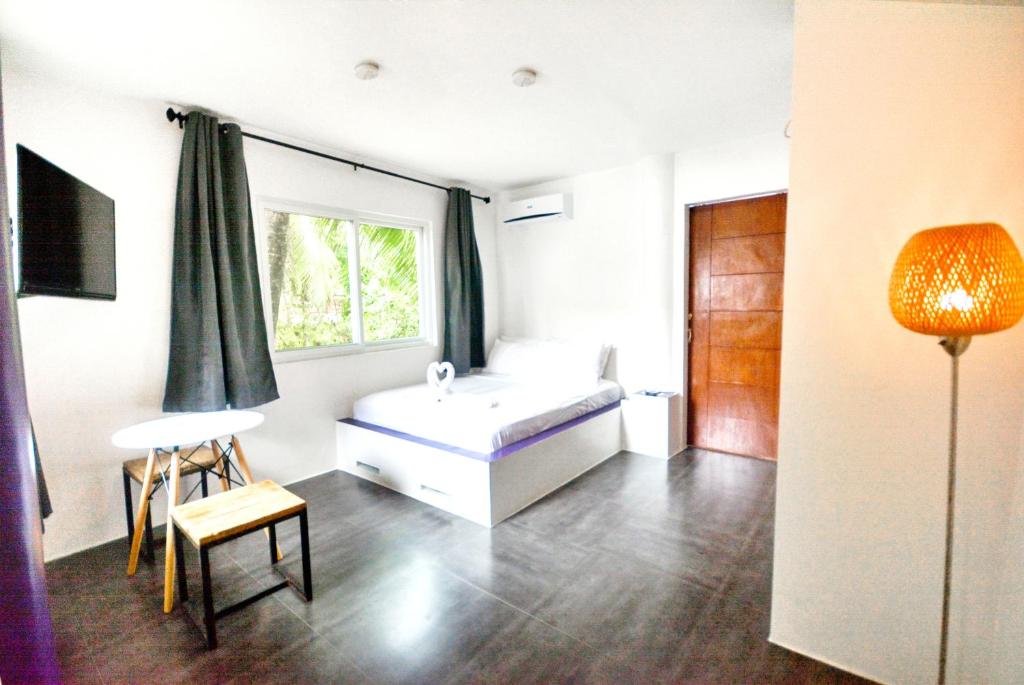 长滩岛BABOSAM Hotel的卧室配有白色的床和窗户。
