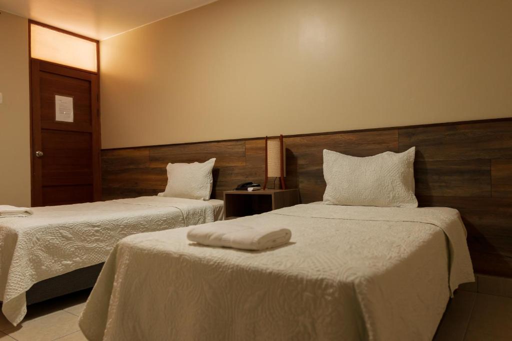 伊察埃尔华卡其内罗酒店的酒店客房,配有两张带白色床单的床