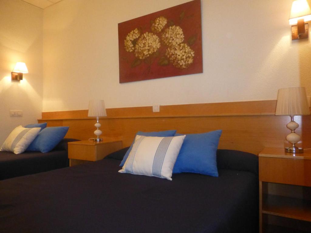 阿尔卡拉德荷那利斯埃尔瓦尔旅馆的酒店的客房 - 带蓝色和白色枕头的床