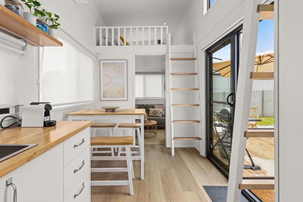 赫斯基森Husky Tiny Home by Experience Jervis Bay的一间小房子,设有厨房和饭厅