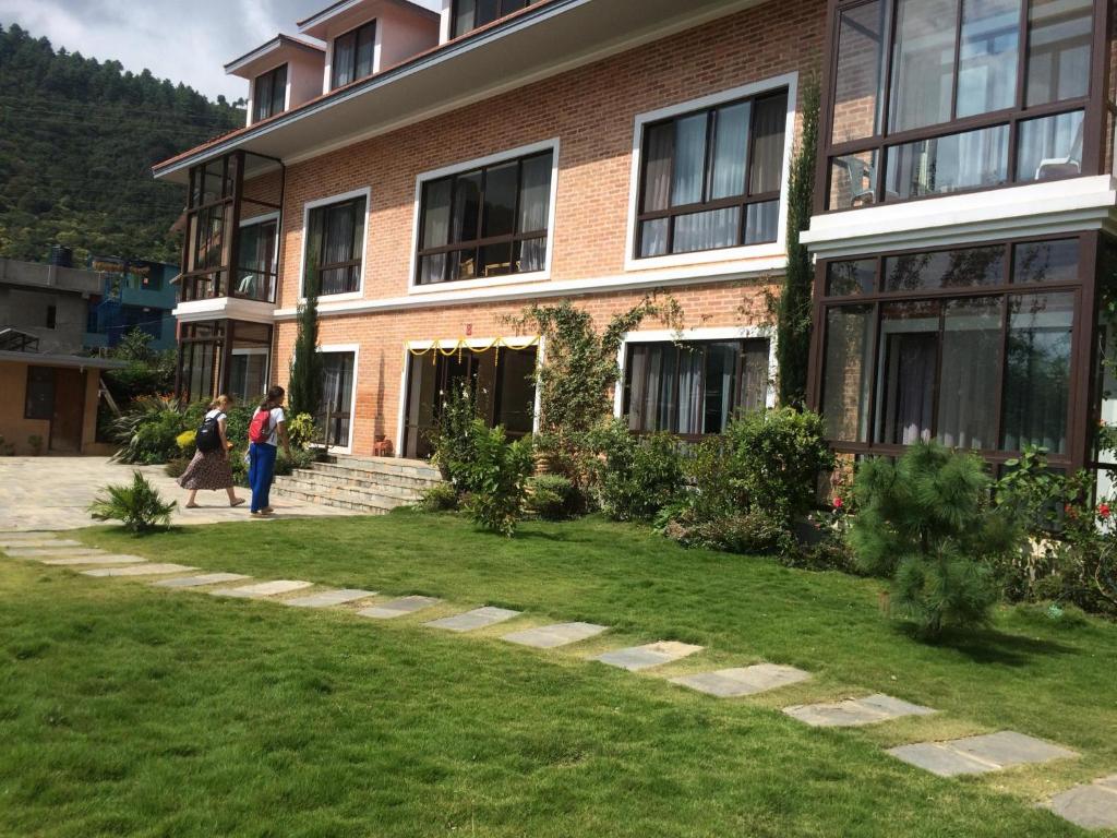 加德满都Drala Resort Nepal的两个人在大楼前走
