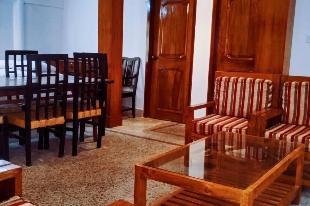 巴纳内拉斯Ashiana Serviced Apartment的客厅设有餐桌和椅子