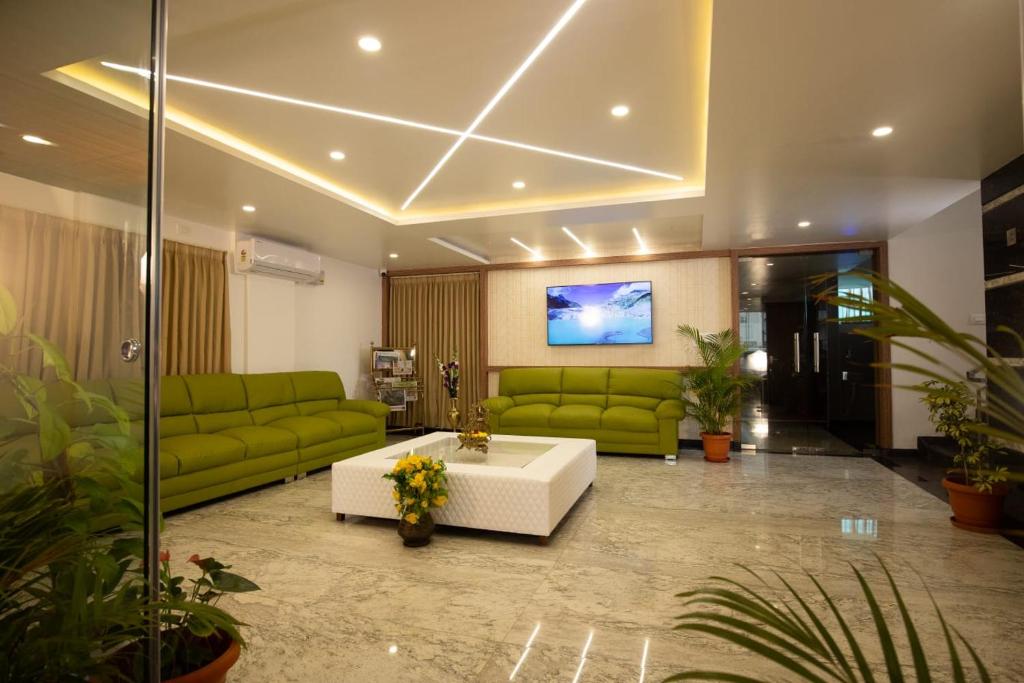 班加罗尔Villa Grand Hotel Near Kempegowda International Airport的客厅配有绿色沙发和沙发