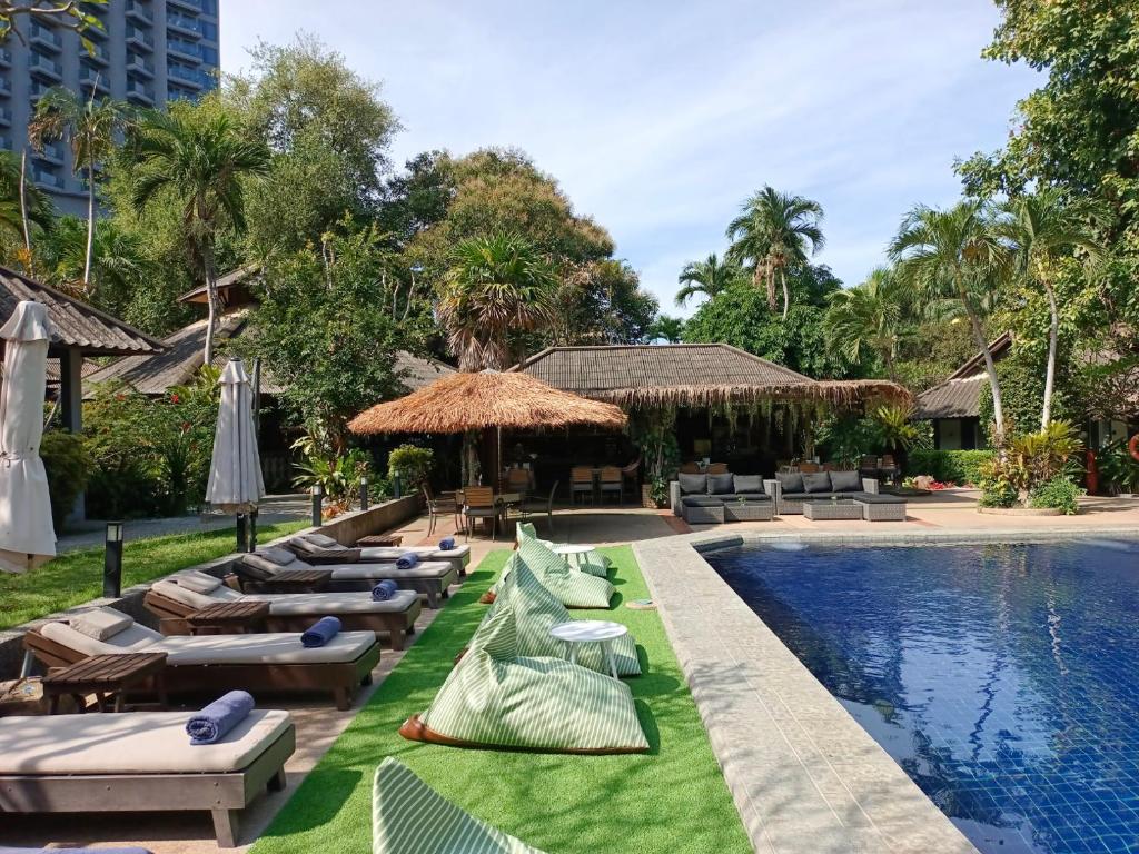 北芭堤雅Let's Hyde Pattaya Resort & Villas - Pool Cabanas的一个带躺椅和游泳池的度假村