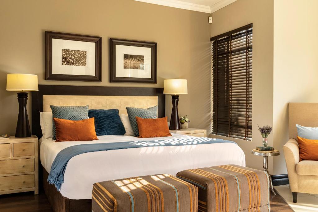 莫科帕内Sofala Lodge的一间卧室配有一张带橙色和蓝色枕头的大床