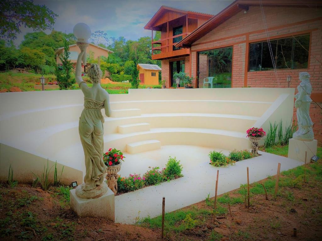 奥索里乌Recanto da Paz - Aos pés do Morro da Borússia的站在花园中的女人的雕像