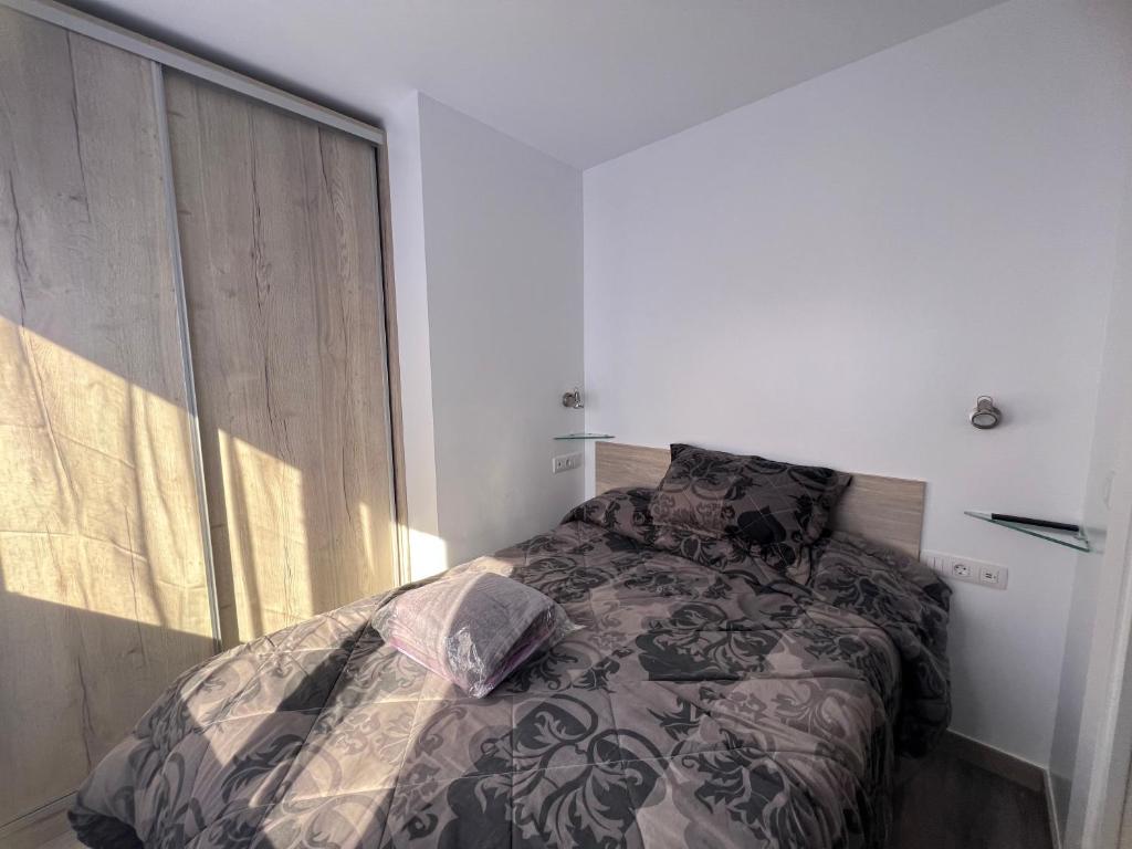 帕斯底拉卡萨SKI CONFORT 02的一间卧室配有一张带床罩的床和窗户