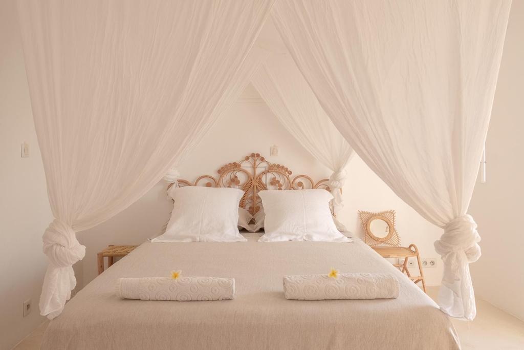 圣皮埃尔La Kazaka Terre Sainte的一张带两个白色枕头和天蓬的白色床