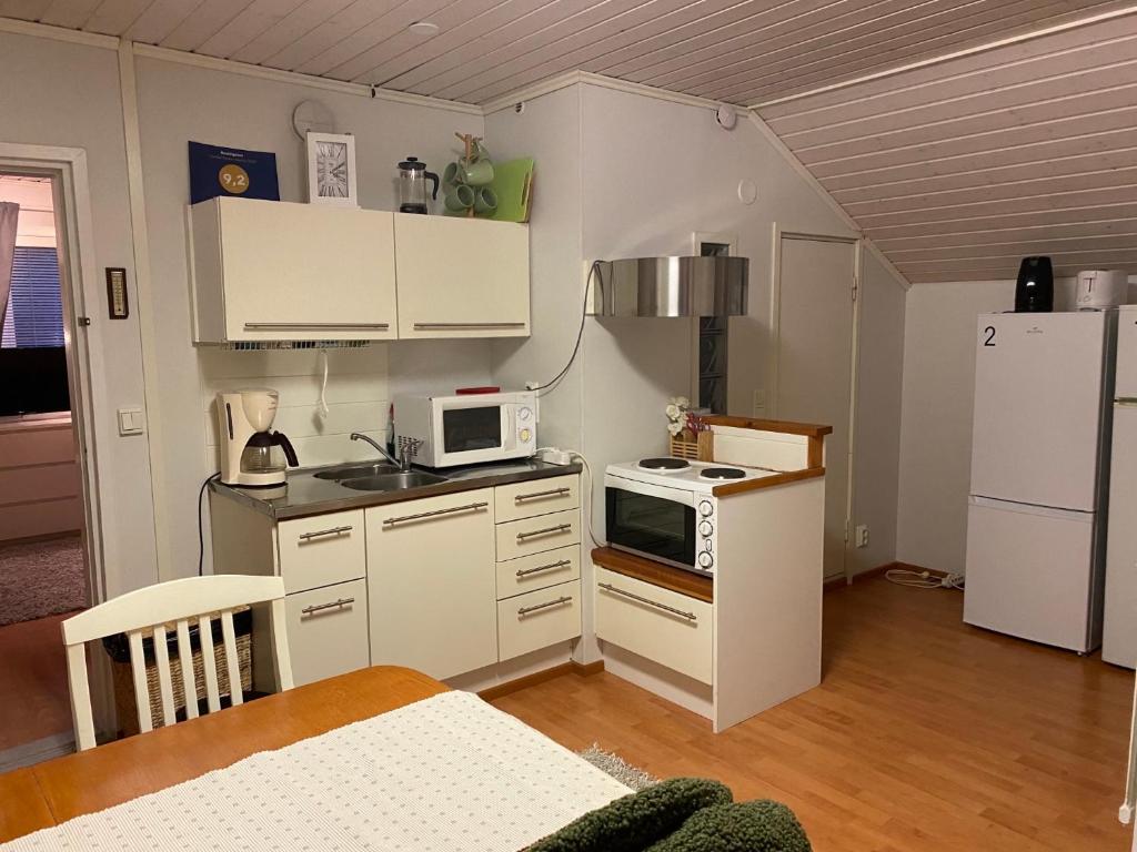 耶姆赛Koskentien kotimajoitus的小厨房配有白色橱柜和白色冰箱