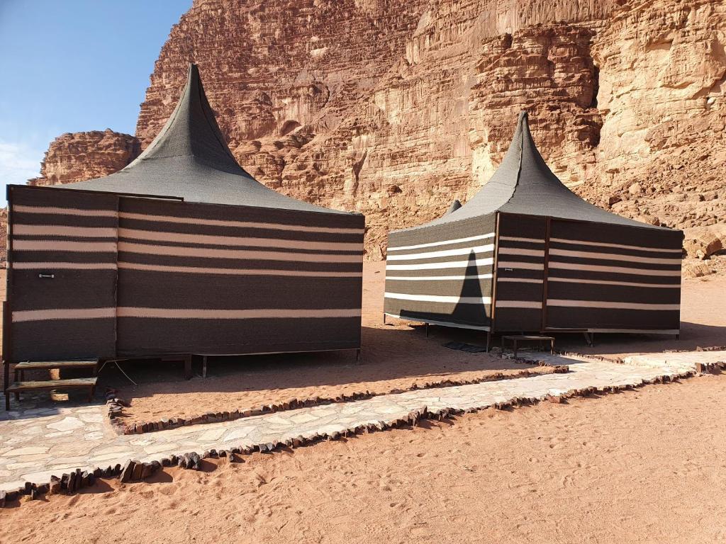瓦迪拉姆Desert Stars rum camp的两个黑白帐篷,位于沙滩上