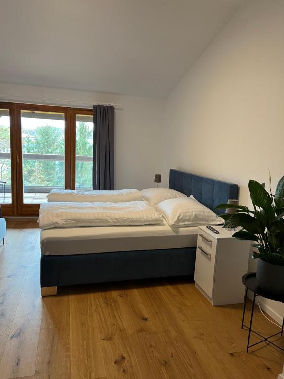 巴特塔茨曼斯多夫Pannonia Appartements的一间卧室配有一张床和盆栽植物