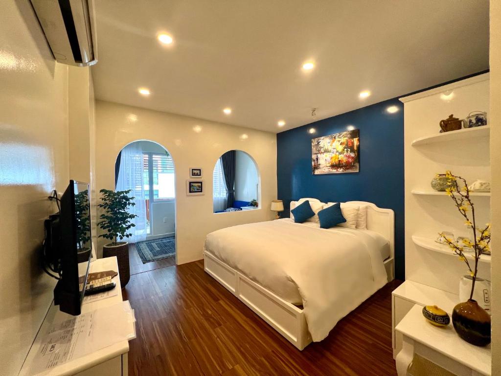 胡志明市Chez Mimosa Corner - New address 90 Đề Thám的一间卧室设有一张蓝色墙壁的大床
