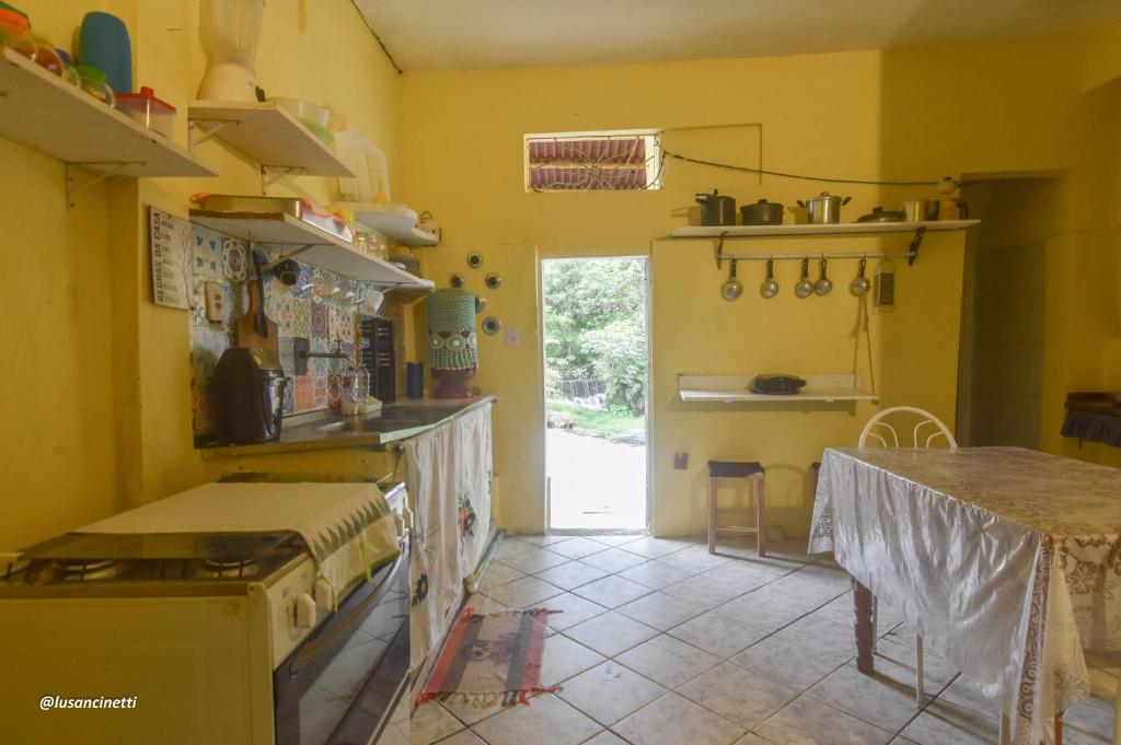伦索伊斯Quinca’s Hostel的厨房设有黄色的墙壁和桌子