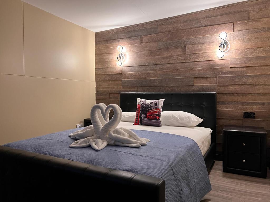 伦敦科莫盖特酒店的一间卧室配有一张带两个天鹅的床