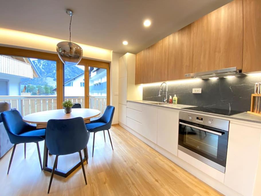 克拉尼斯卡戈拉Lux Apartment Ski&Golf的厨房配有桌子和蓝色椅子