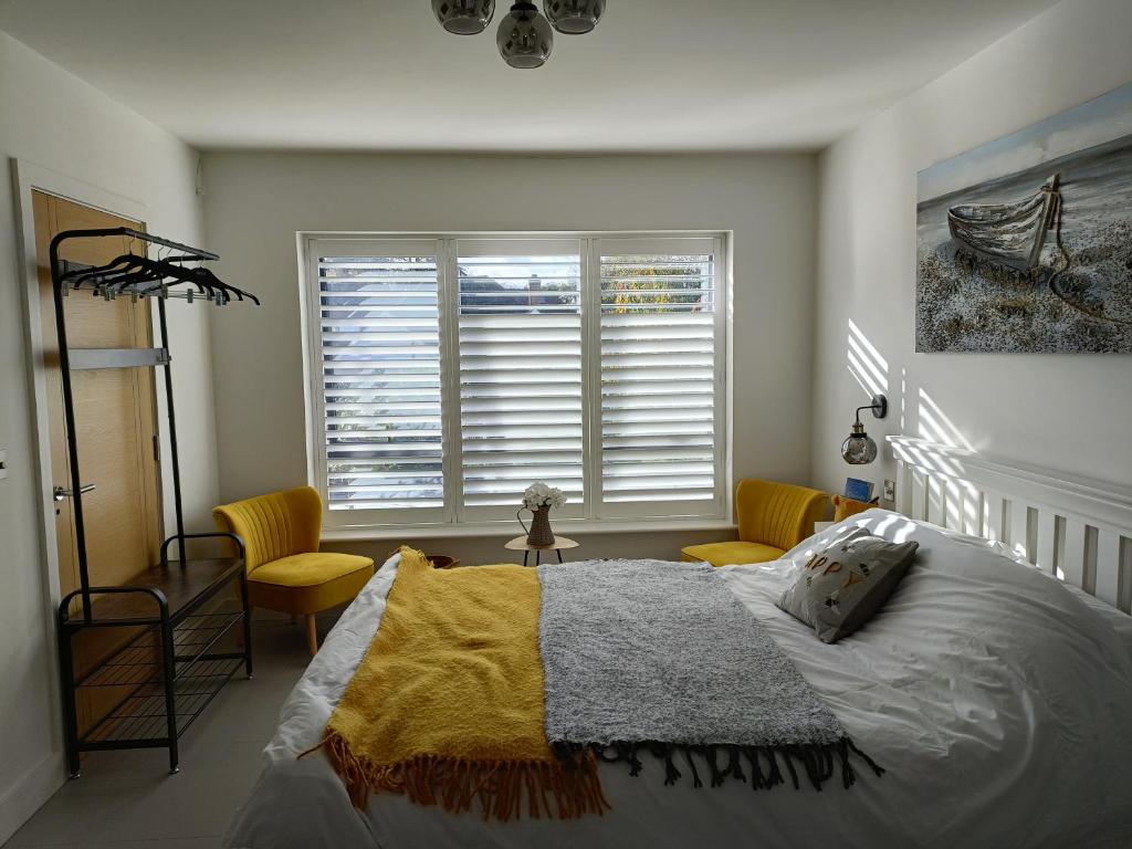 基督城Petite Anchorage的一间卧室配有床、椅子和窗户