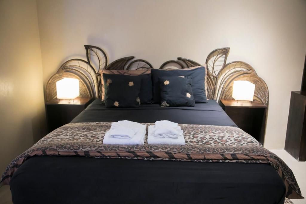 Boscobel默克松斯海滩俱乐部酒店的一间卧室配有一张床,上面有两条毛巾