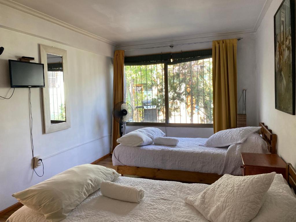 圣地亚哥El Pillan "Travelers" House的一间卧室设有两张床和窗户。