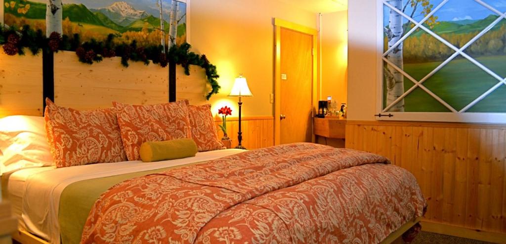 温索普Chewuch Inn & Cabins的卧室配有一张床,墙上挂有绘画作品