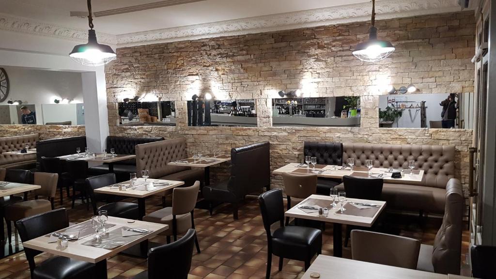 大圣富瓦维克多·雨果餐厅酒店的一间带桌椅的餐厅以及砖墙