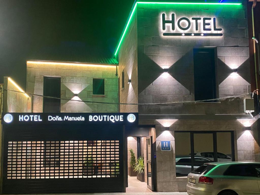 托梅略索HOTEL BOUTIQUE DOÑA MANUELA的夜间在门前停车的酒店