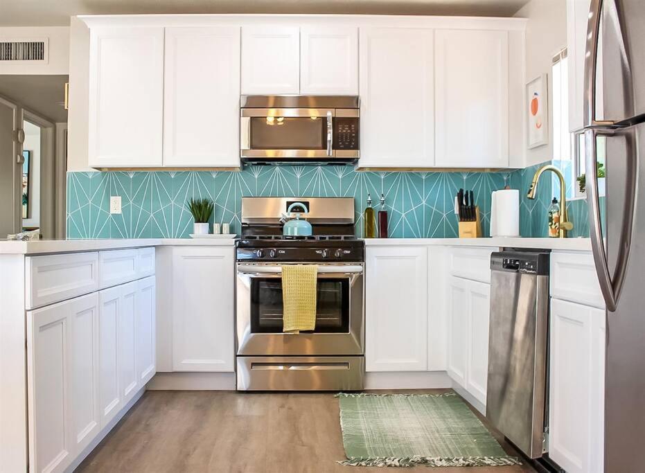 凤凰城Newly Remodeled Mid Century Saguaro House (36)的厨房配有白色橱柜和不锈钢烤箱