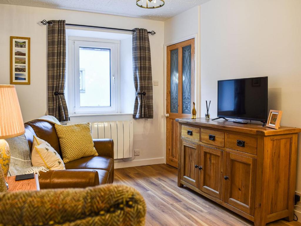 NewbyNumber 6 - Uk33332的客厅配有沙发和木柜上的电视