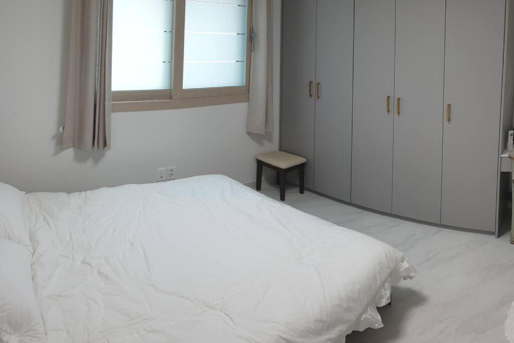 庆州Gyeongju Sugi's Guesthouse的白色的卧室设有白色的床和窗户。