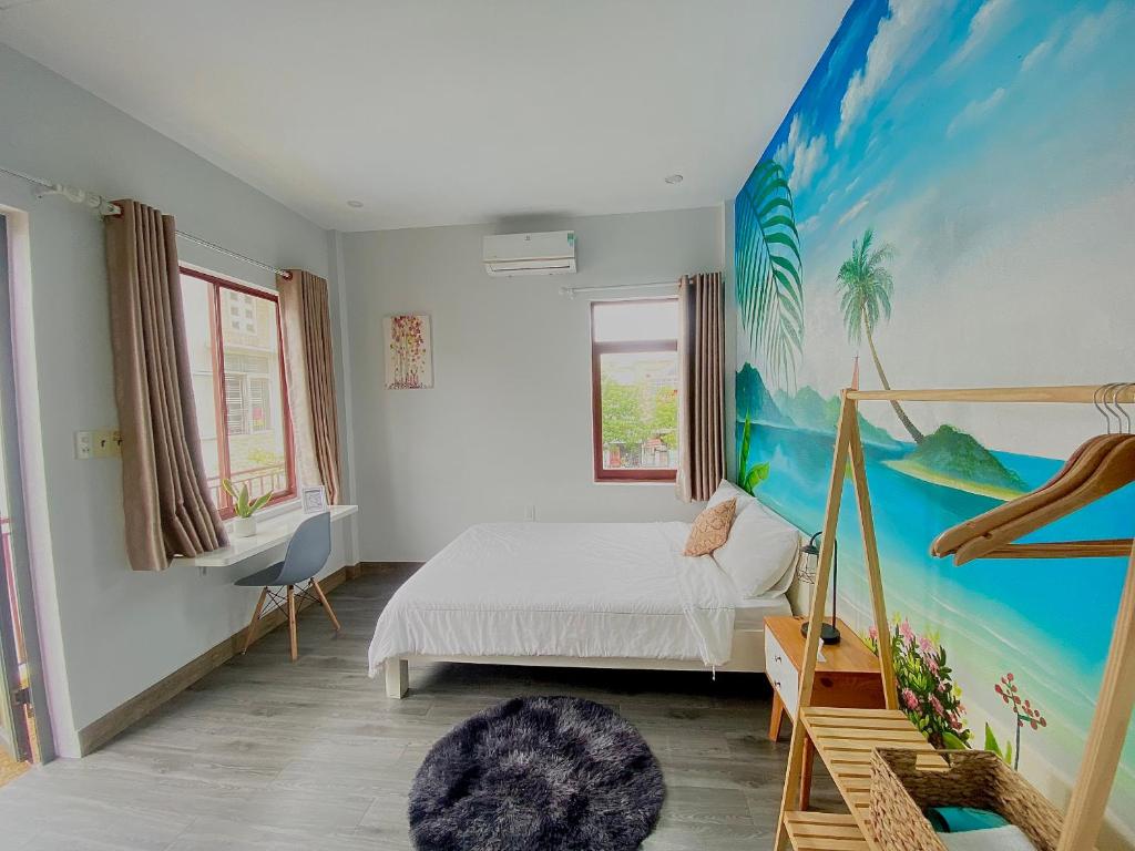 顺化Tùng Homestay的卧室配有一张床,墙上挂有绘画作品
