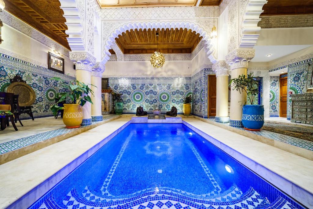 非斯Riad Rcif Alif Suite & SPA的一座游泳池,位于一座大房间,有一座建筑