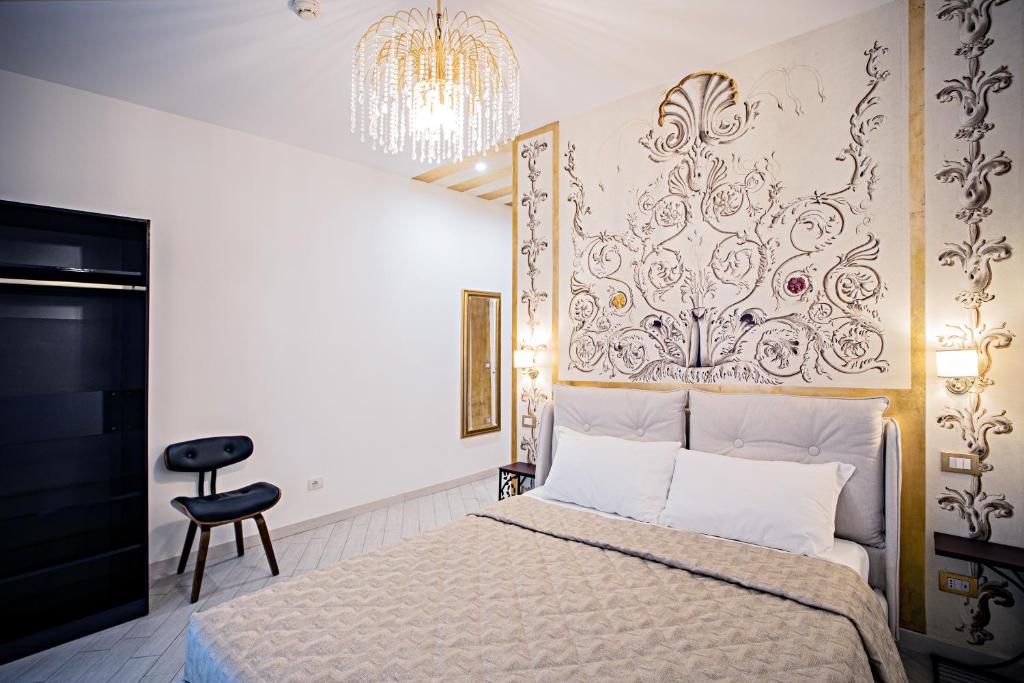 罗马LUDUS ROOMS的一间卧室配有一张床和一个吊灯