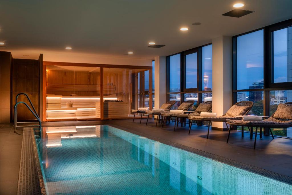 柏林SANA柏林酒店的酒店游泳池设有桌椅和窗户
