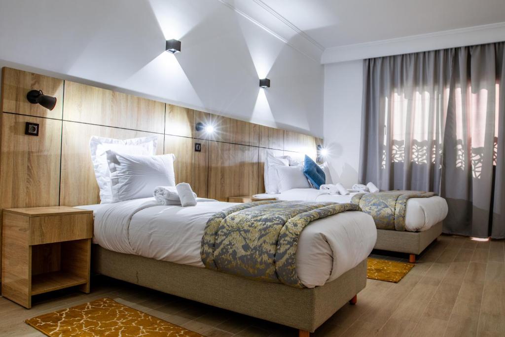达赫拉Karam City Hotel的酒店客房设有两张床和大窗户。