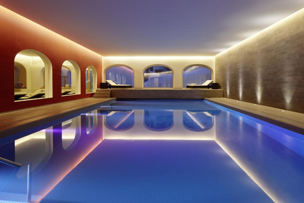 圣莫里茨斯特凡尼酒店的大楼内的一个蓝色海水游泳池