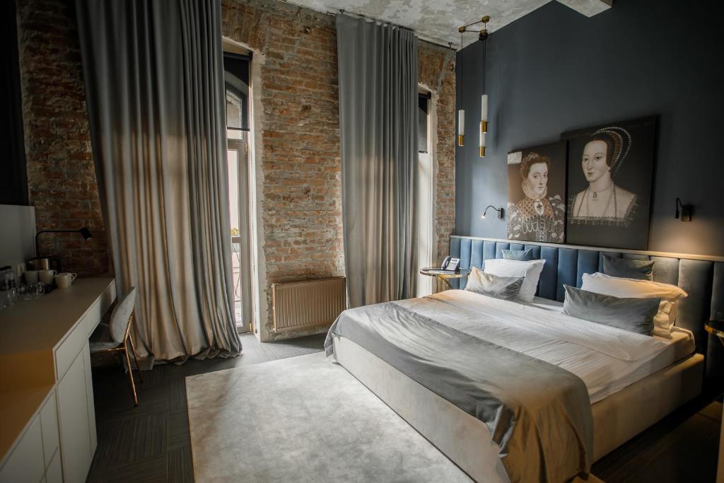 切尔诺夫策Victoria Deluxe Hotel的一间卧室设有一张床和砖墙