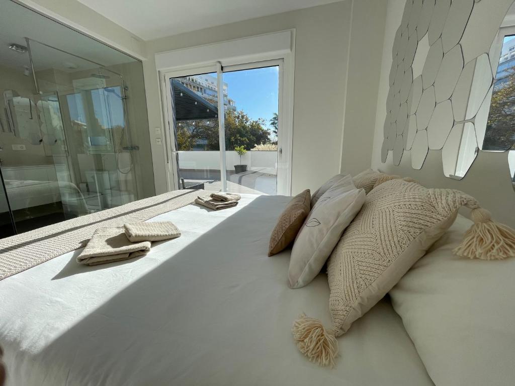 马贝拉Marbella Centre with terrace and pool的一张带两个枕头和窗户的大型白色床