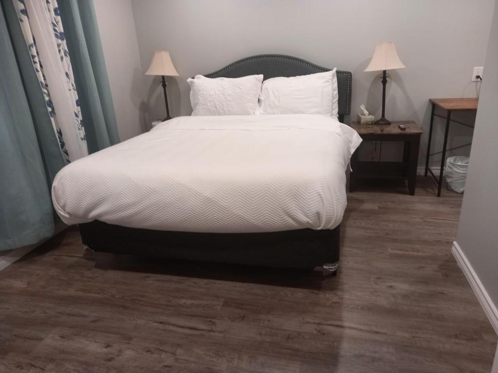 金斯顿Splendid Place的卧室内的一张带白色床单和枕头的床