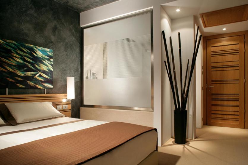 瓦多利古雷Sea Art Hotel的卧室配有一张床,墙上挂有绘画作品