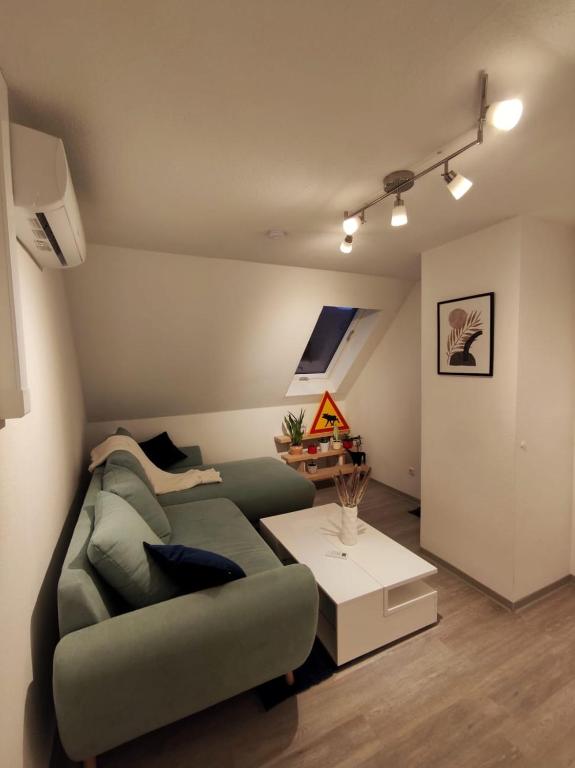 门登Dachgeschosswohnung mit Klimaanlage in bester Lage的客厅配有绿色沙发和桌子