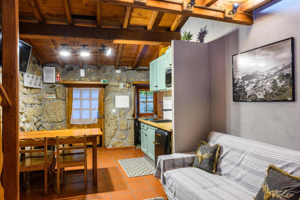 萨布盖鲁Casa do Tio Ferreiro的厨房以及带沙发和桌子的客厅。