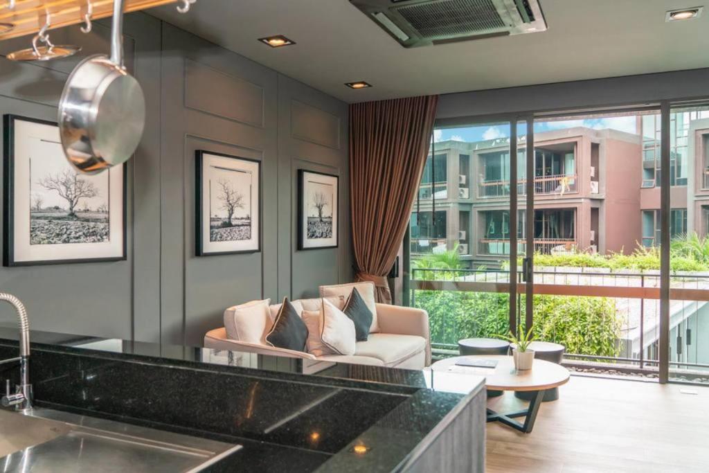拉威海滩Luxury King Bed Apartment with Pool View and Sauna的厨房以及带沙发和桌子的客厅。