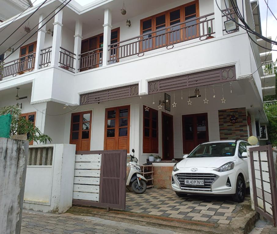 科钦PRAKRITI HOMESTAY Fortkochi Air Conditioned Rooms的停在房子前面的白色汽车