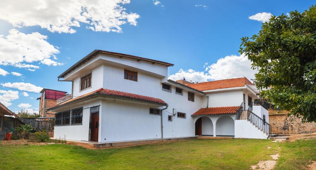 Los Baños del IncaCasa de campo Villa Acosta的白色房子,有红色屋顶
