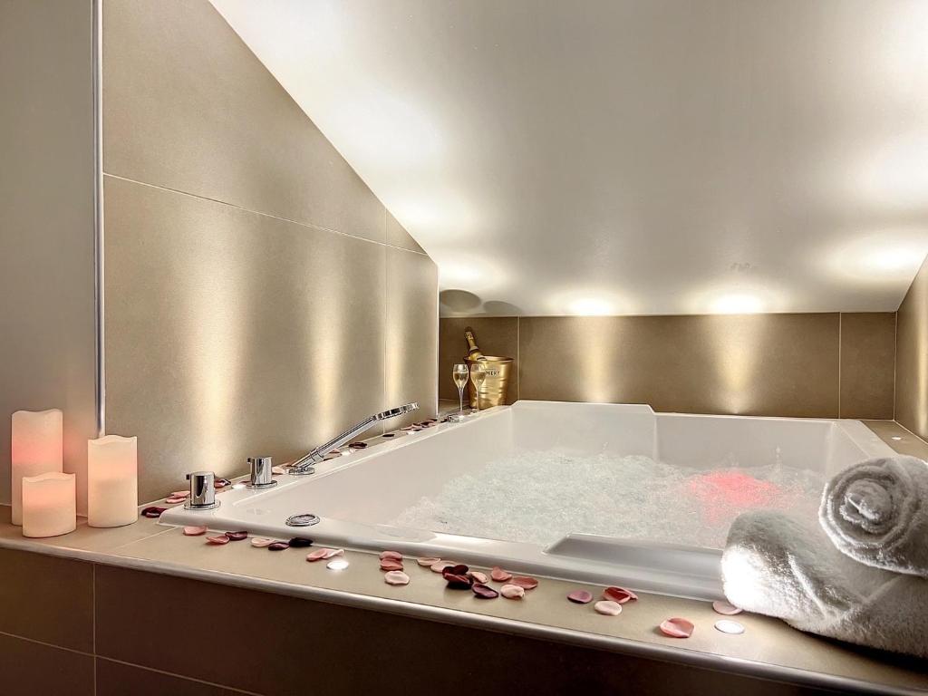 圣艾蒂安Cocon Blanc câlin - Jacuzzi privatif - Love Room à Saint Etienne的一间带浴缸和镜子的浴室