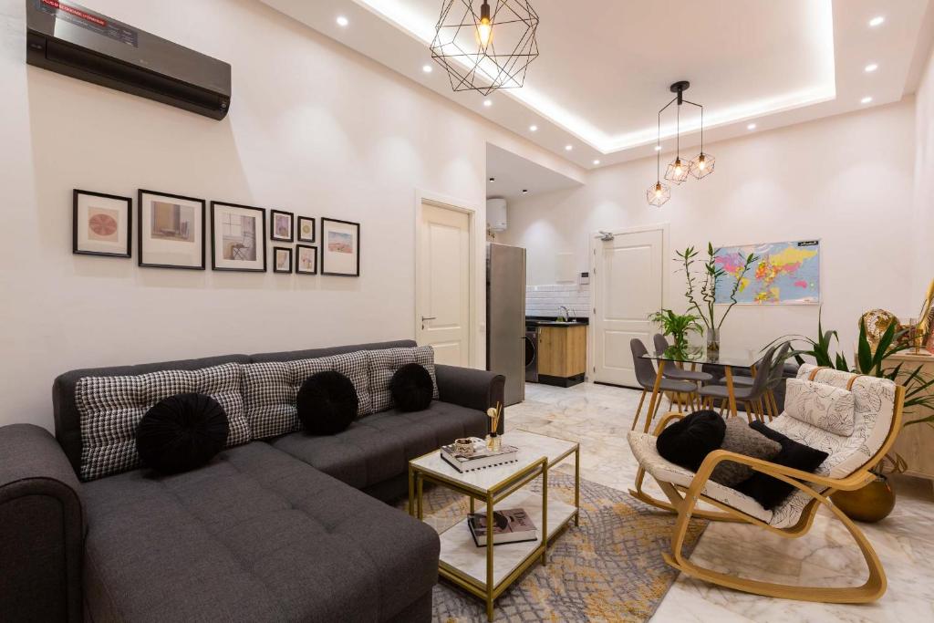 DerrouaAirport Apartment Suite Casablanca FREE WIFI Modern Confort Calme的客厅配有沙发、椅子和桌子
