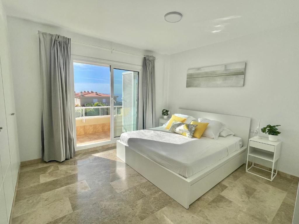 圣地亚哥港The Retreat House - Private Pool的白色的卧室设有床和大窗户